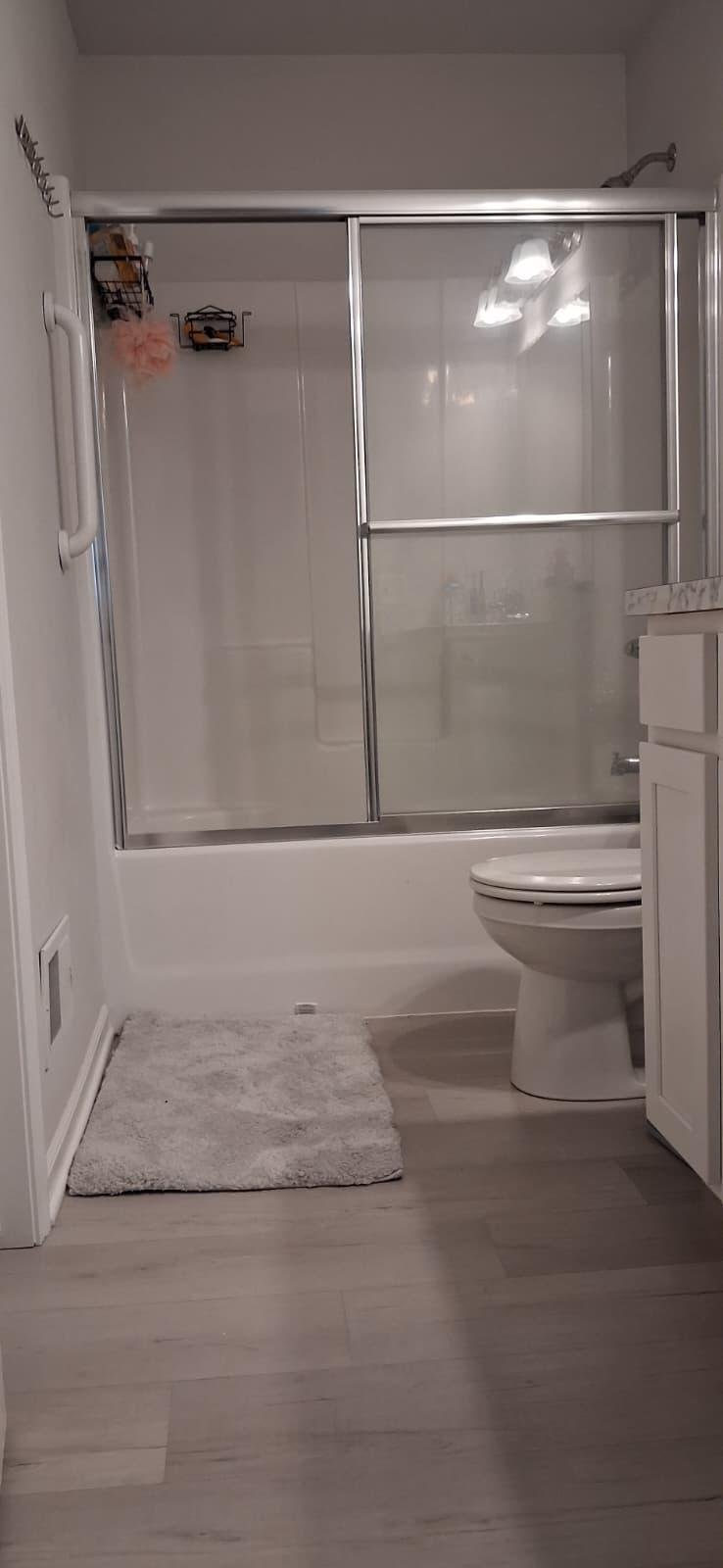 Accessible bathroom with a walk-in shower and grab bars at Angie Home Care AFC