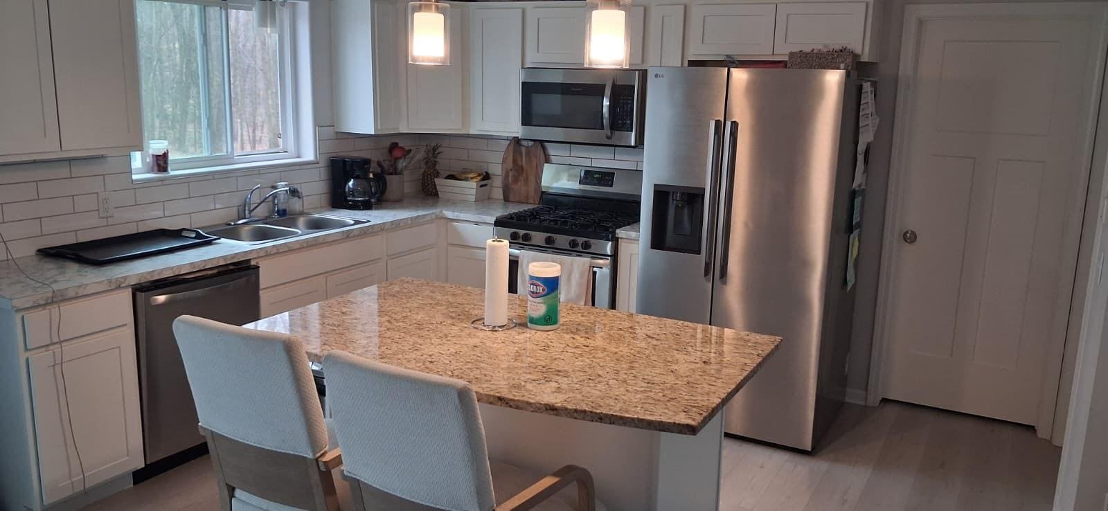 Clean, modern kitchen with a granite island at Angie Home Care AFC